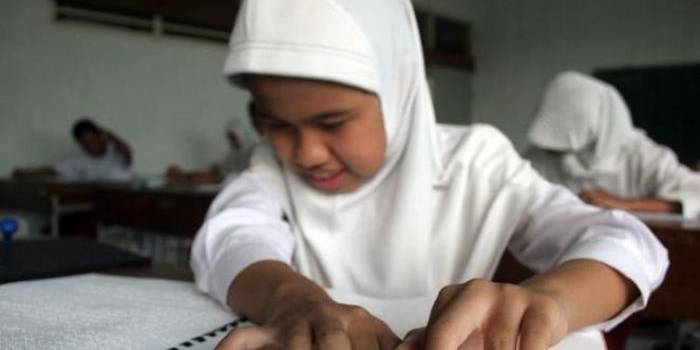 Seorang siswi SD disalah satu SLB di Yogyakarta sedang mengerjakan Ujian Nasional. foto: viva.co.id