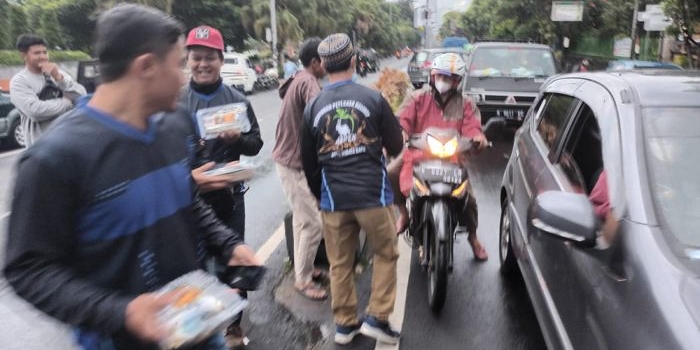 Para Anggota Aspek Kota Batu saat membagikan takjil kepada para pengguna jalan yang melintas di sekitar Balai Kota Batu. foto: ADI WIYONO/ BANGSAONLINE