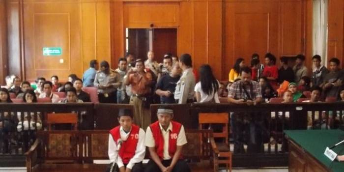 Dua terdakwa sesaat sebelum menjalani sidang pengeroyokan sesama Bonek, Senin (10/3/2014). foto:faishal/BANGSA ONLINE