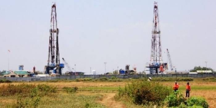 LAPANGAN SUKOWATI. Dua menara menjulang tinggi di Pad B Desa Ngampel, Kecamatan Kapas, Bojonegoro. Sementara sumur SKW 21 yang bocor berada di Pad A JOB P-PEJ. Foto: Eki Nurhadi/BANGSAONLINE