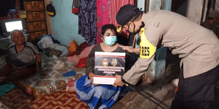 Kapolres Pasuruan AKBP Rofiq Ripto Himawan menyerahkan paket sembako secara door to door kepada warga terdampak Covid-19.