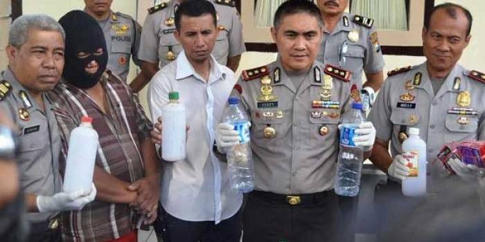 Petugas menunjukan BB berupa Miras oplosan serta Sugeng yang telah ditetapkan tersangka. (foto: tri susanto/BANGSAONLINE)