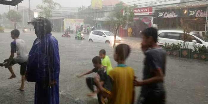 Genangan air yang terjadi di Jalan Dr. Wahidin SH Kebomas saat hujan deras. foto: SYUHUD/ BANGSAONLINE