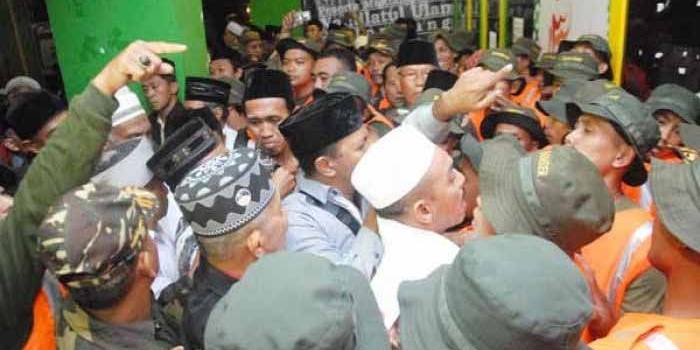 Anggota Banser saling dorong dengan rombongan dari PWNU NTT saat registrasi Muktamar ke-33 NU. (foto: rony suhartomo/BANGSAONLINE)
