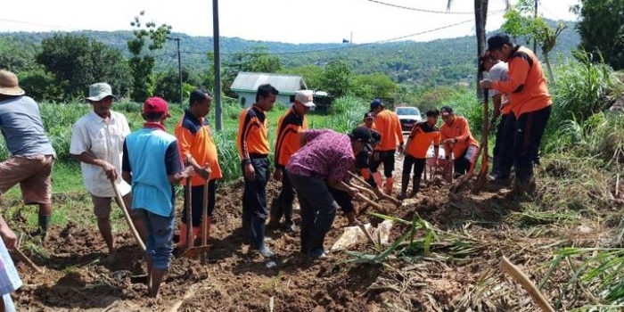 Personel TNI-Polri, BPBD, Pemerintah Kecamatan Waru, dan warga setempat saat membersihkan material longsor untuk membuka akses jalan yang menghubungkan dua desa. 