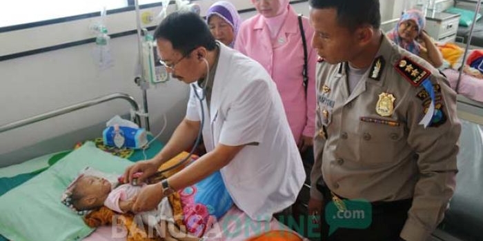 Kapolres Kediri AKBP Sumaryono saat menjenguk balita yang diduga kekurangan gizi. foto: ARIF KURNIAWAN/ BANGSAONLINE