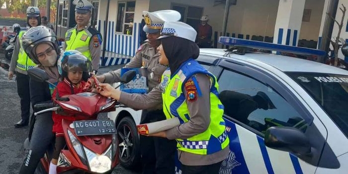 Pengguna jalan saat mendapat coklat karena tertib berlalu lintas oleh petugas dari Polres Kediri Kota . Foto: Ist