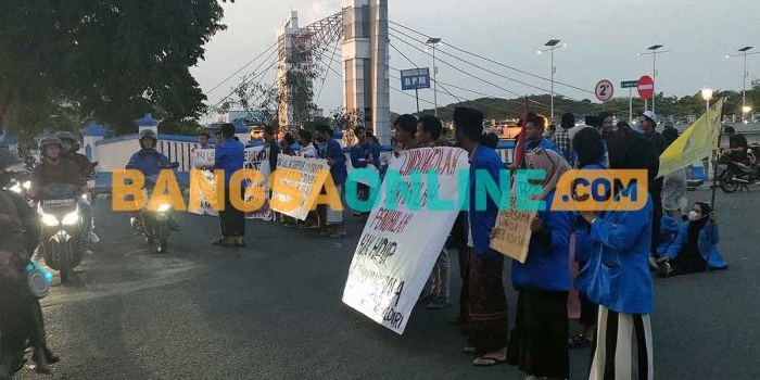 Para mahasiswa yang tergabung dalam PMII Kediri saat berorasi di pinggir jalan dan menutup sisi barat Jembatan Brantas Lama. Foto: MUJI HARJITA/BANGSAONLINE