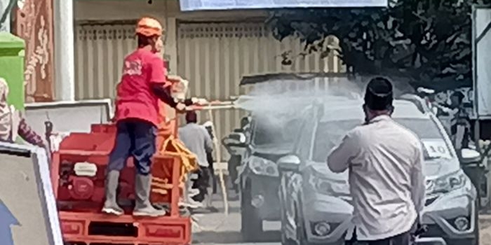 Petugas dan panitia menghentikan setiap mobil pengantar di pintu gerbang Ponpes Lirboyo, untuk disemprot disinfektan. foto: MUJI HARJITA/ BANGSAONLINE