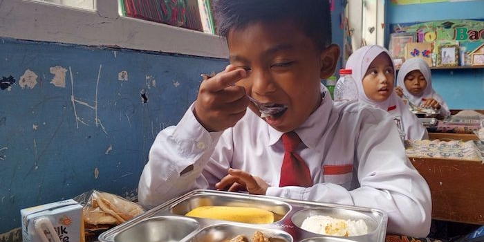 Seorang siswa di Pamekasan saat mendapat paket makanan program MBG