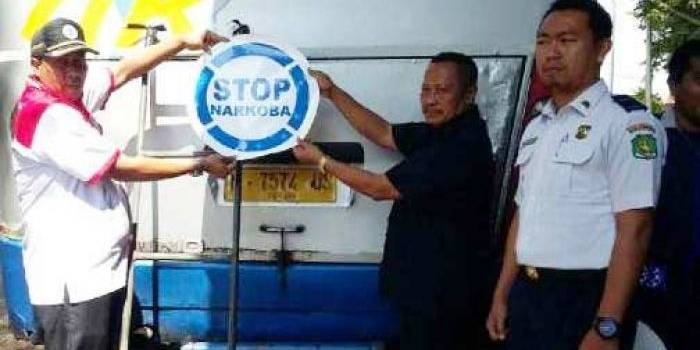 Penempelan stiker “STOP NARKOBA” di bagian belakang bus yang terparkir di terminal Arya Wiraraja. foto: rahmatullah/ BANGSAONLINE
