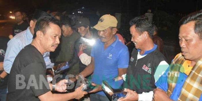 Bupati Jombang, Nyono Suharli Wihandoko saat membagikan menu santap sahur kepada para abang becak di sekitar stasiun Jombang, Minggu 918/6/2017) dini hari. foto: ROMZA/ BANGSAONLINE