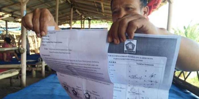TUNJUKKAN: Ketua PAC Partai Gerindra Kecamatan Pesantren, Hartono, saat menunjukkan surat mosi tidak percaya kepada Ketua DPC mereka. foto: arif kurniawan/BANGSAONLINE
