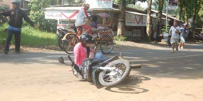 Salah satu wanita yang terjatuh saat melintas di tikungan barat Jembatan Jagalan, Ngantru, Trenggalek. foto: herman/ BANGSAONLINE