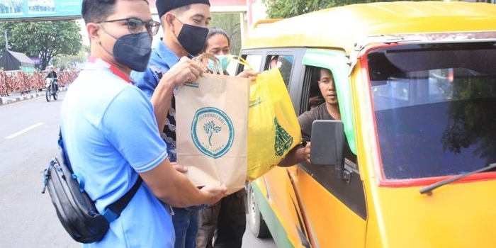 PEDULI: Ketua PWI Sidoarjo Abdul Rouf dan perwakilan Alfamart menyerahkan sembako kepada para sopir angkot, Jumat (22/4/2022). foto: istimewa