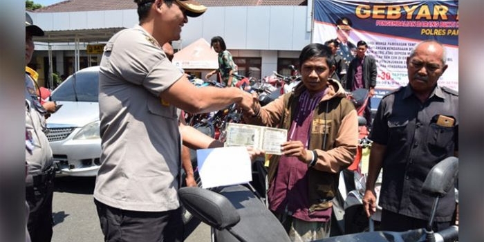 Wakapolres Pamekasan sedang menyerahkan surat-surat berikut kendaraan kepada pemiliknya.