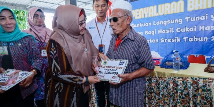 Plt Bupati Gresik Aminatun Habibah menyerahkan bantuan BLT DBHCHT kepada warga kurang beruntung. Foto: Ist.