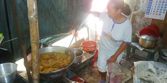 GORENG. Wiji Ismuni saat menggoreng keripik pisang di rumahnya Foto: eky nurhadi/BANGSAONLINE