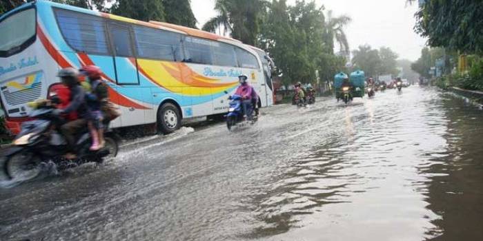 Kendaraan bus ini bergerak lambat akibat genangan banjir, setelah diguyur hujan deras Jumat malam. (ft: rony suhartomo/ BANGSAONLINE)