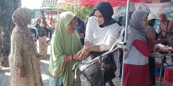 Mimik Idayana menyapa seorang nenek di sela membagikan makanan gratis. Foto: Ist