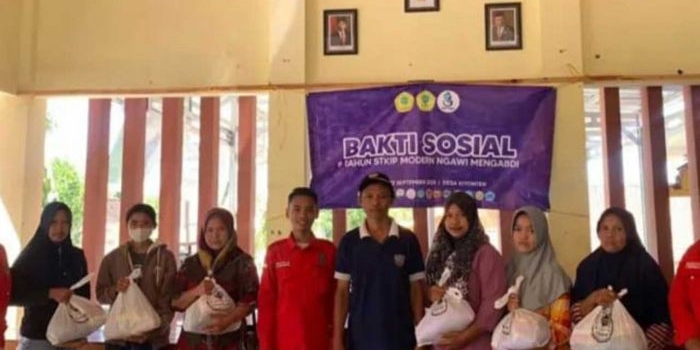 Foto bersama sejumlah mahasiswa STKIP Modern Ngawi bersama warga penerima bantuan sembako.