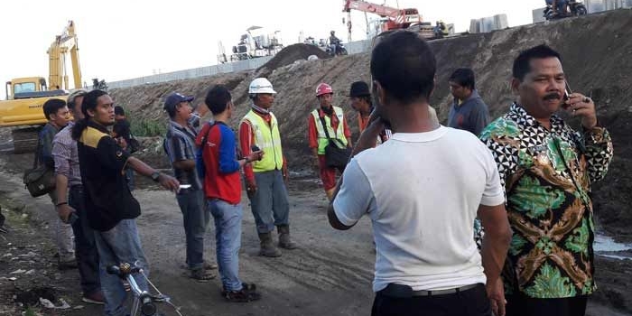 Kades Sumput Driyorejo H. Sutaji bersama warganya saat memprotes proyek tol Sumo.  foto: SYUHUD/ BANGSAONLINE