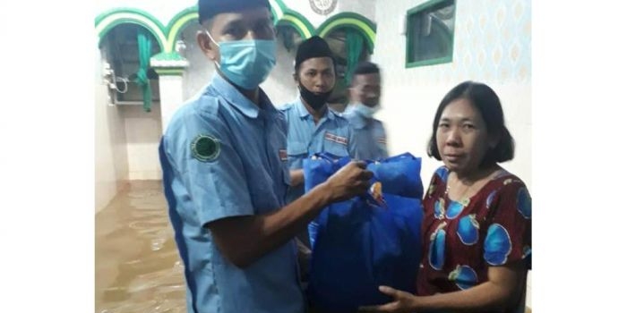 Para pengurus Badan Komunikasi Pemuda Remaja Masjid Indonesia (BKPRMI) saat menyalurkan bantuan sembako kepada korban banjir di tanah rendah kampung melayu Jakarta Timur, Minggu (21/2/2021). foto: ist.