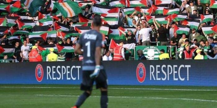 Aksi suporter Celtic saat mengibarkan bendera Palestina di tengah laga melawan Hapoel Beer Sheva pada kualifikasi Liga Champions di Celtic Park, Inggris (18/8).