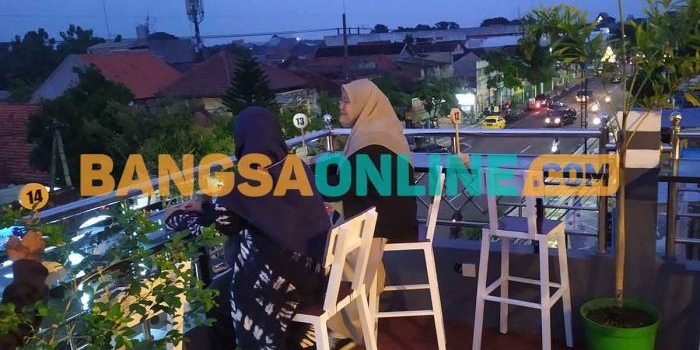 Pengunjung Maungopi Cafe saat menikmati pemandangan Kota Jombang dari ketinggian. Foto: AAN AMRULLOH/BANGSAONLINE