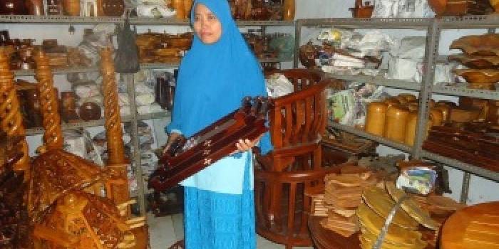 SOUVENIR. Rohmah salah satu pemilik galeri di Kecamatan Kasiman sedang menunjukan souvenir kayu jatinya. Foto: Eky Nurhadi/BANGSAONLINE
