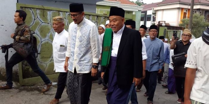 Foto inilah yang kini viral. Foto ini diambil saat Sandiaga Uno jadi pembicara di Pondok Pesantren Amanatul Ummah Desa Kembangbelor Pacet Mojokerto Jawa Timur, Sabtu (10/6/2017). Tampak Sandiaga Uno bersama Kiai Asep sedang menuju tempat seminar tersebut. Foto: istimewa
