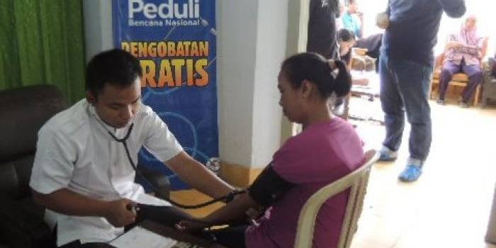 SEHAT. Petugas kesehatan sedang memeriksa seorang warga Mangli. 