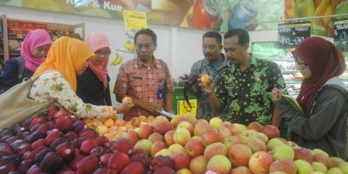 SIDAK: Petugas Dinkes dan Disperindag Bojonegoro melakukan sidak di beberapa toko buah. Hasilnya petugas menemukan apel impor jenis Granny Smith dan Gala Red yang masih terjual. Foto: Eky Nurhadi/BangsaOnline