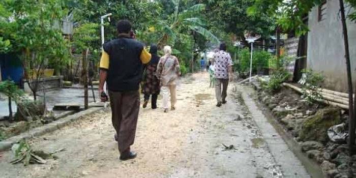  Warga tengah melintas di jalan desa yang belum tersentuh program JPD. (foto: syuhud/BANGSAONLINE)