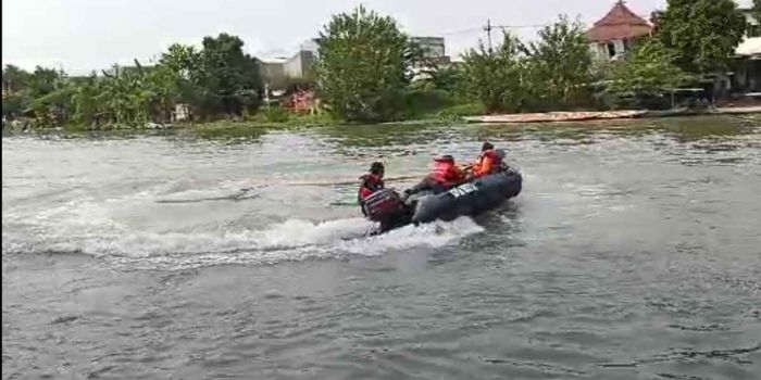 Petugas gabungan saat menyisir sekitar lokasi tenggelamnya 2 balita di Sungai Rolak, Surabaya.