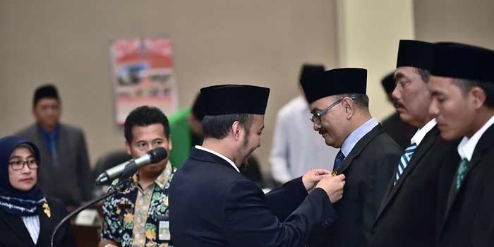 Ketua DPRD Lamongan Debby Kurniawan saat memasangkan pin kepada tiga anggota DPRD yang baru dilantik.
