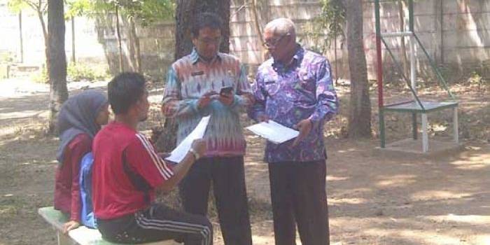 DIDATA – Petugas Disdikporada mendata siswa yang tepergok berada di Stadion, saat jam sekolah. foto: soewandito/BANGSAONLINE