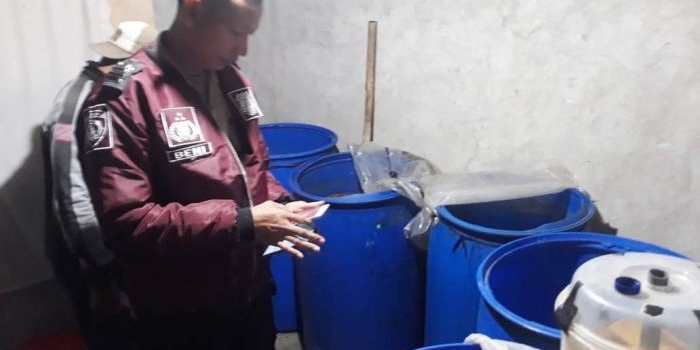 Petugas memeriksa sejumlah barang butki berupa peralatan untuk memproduksi arak.
