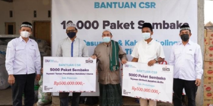 General Manager of CSR SIG, Edy Saraya (kanan) menyerahkan bantuan paket sembako secara simbolis kepada pengurus yayasan Brilian Azzahra Arifin dan yayasan  YPTNU di Probolinggo. foto: ist.
