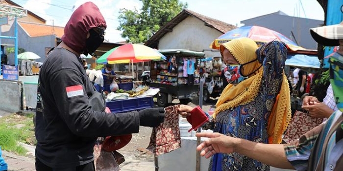Para petugas sedang membagikan masker di Pasar Krempyeng Dukuh Bulak Banteng dan Pasar Podomoro.?