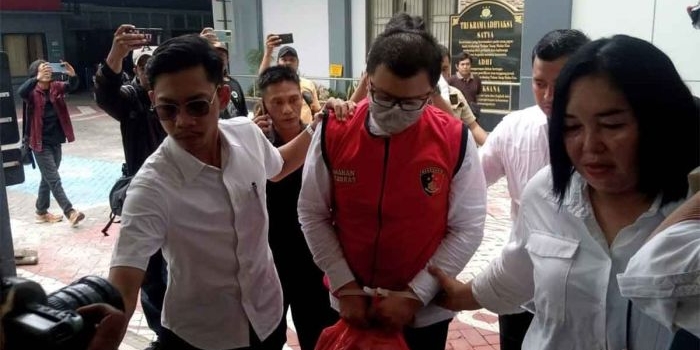 Tersangka penganiayaan saat mengenakan baju tahanan.