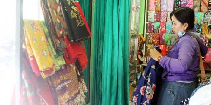 Satu calon pembeli kebingungan memilih motif batik. foto: faratiti dewi/BANGSA ONLINE