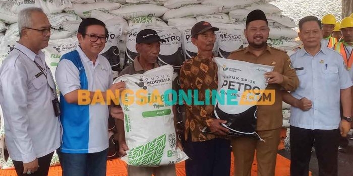 Bupati Gresik, Fandi Akhmad Yani, dan Direktur Utama Petrokimia Gresik, Dwi Satriyo Annurogo, saat penyerahan pupuk kepada petani. Foto: SYUHUD/BANGSAONLINE