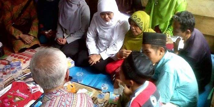 Menteri Sosial Khofifah Indar Parawansa di tengah keluarga almarhum Yuyun saat berkunjung ke rumah duka. 