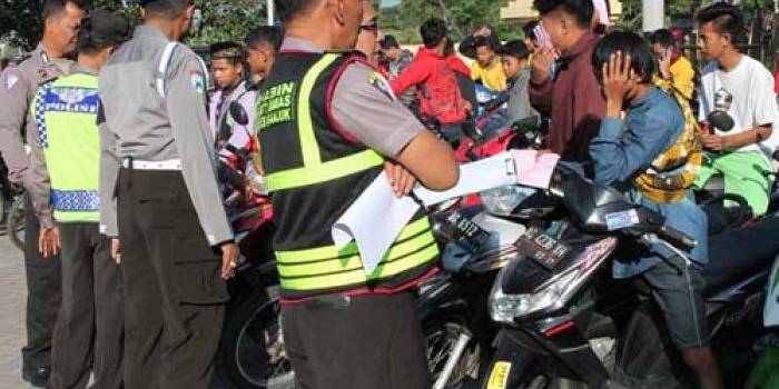 DIAMANKAN - Pembalap liar dan motornya saat diamankan di Mapolres Nganjuk. (foto: soewandito/BANGSAONLINE)