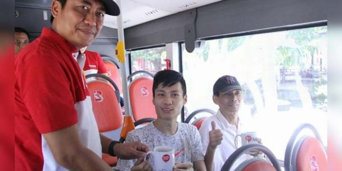 Kepala Dishub Kota Surabaya Irvan Wahyudrajad saat memberikan suvenir kepada penumpang Suroboyo Bus. foto: ist