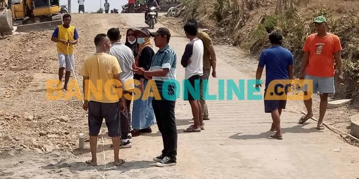 Warga bersama perwakilan pengembang ketika mengukur ulang lebar jalan. Foto: HENDRO SUHARTONO/BANGSAONLINE