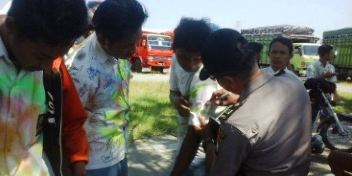 Anggota Polisi saat membubuhkan tanda tangan salah seorang pelajar saat merayakan kelulusan. (foto: dendi martoni/BANGSAONLINE)