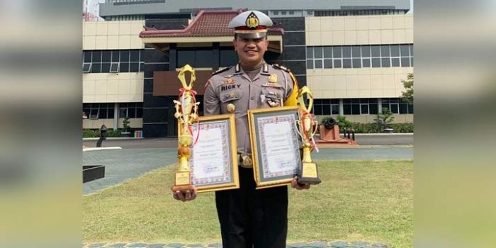 Kasatlantas Polres Tuban AKP Ricky Tri Dharma menunjukkan piala dan piagam penghargaan untuk Posyan Terbaik.
