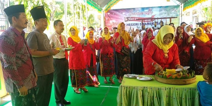 Kepala SMPN 5 Pamekasan Sulistyawaty, S.Pd., M.Pd. saat memotong tumpeng dalam acara peringatan hari jadi yang ke-35.